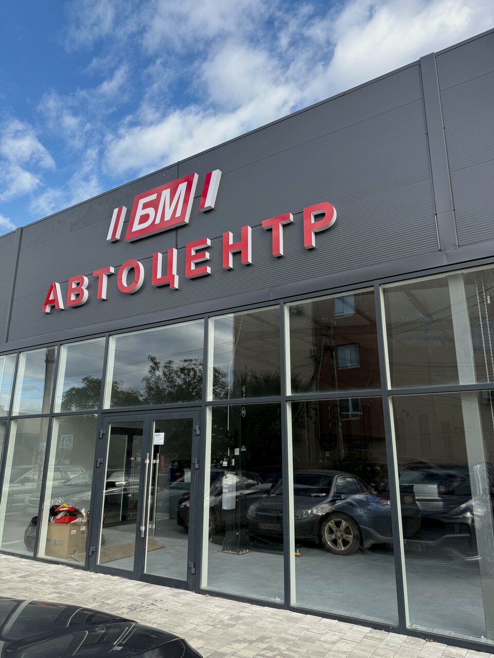 Здание БМ Автоцентра на улице 1 Мая с красной вывеской